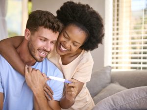 Happy couple celebrates a positive pregnancy test, reflecting successful IVF results after intrauterine G-CSF infusion therapy.