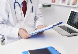 A fertility doctor in a lab coat reviews patient documents, reflecting the careful planning behind successful IVF procedures.