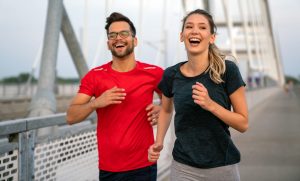 Ein lächelndes Paar joggt im Freien, ein Symbol für Vitalität und emotionales Wohlbefinden nach erfolgreichen icsi-ivf-Ergebnissen.