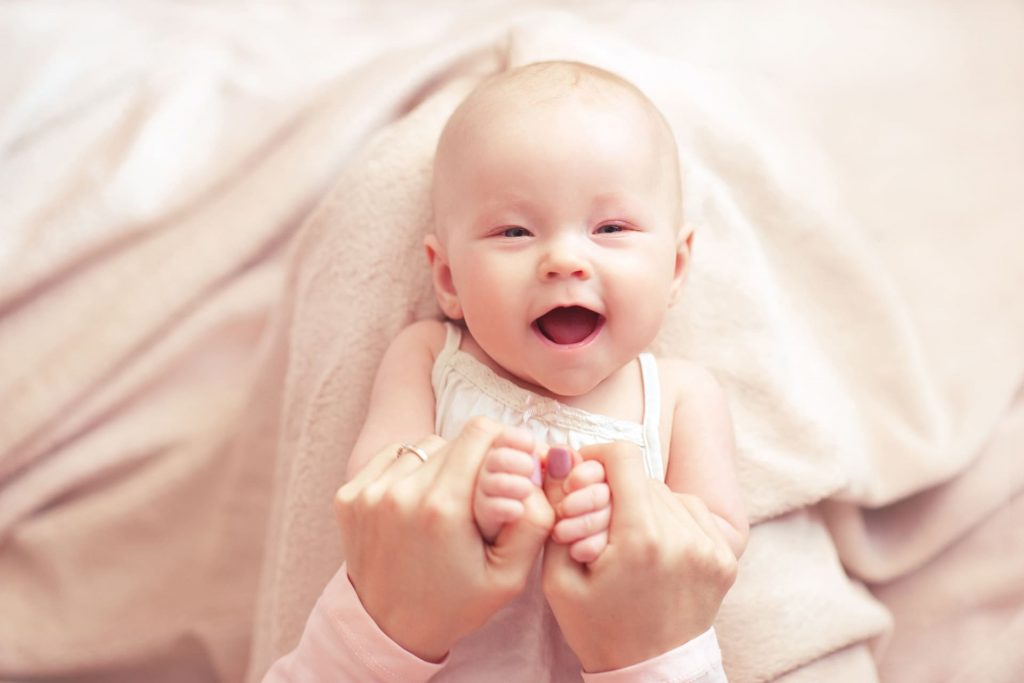 Glückliches Neugeborenes sanft gehalten nach erfolgreicher IVF-Behandlung bei Myomen, symbolisiert emotionale Erfüllung und natürliche Fruchtbarkeit.