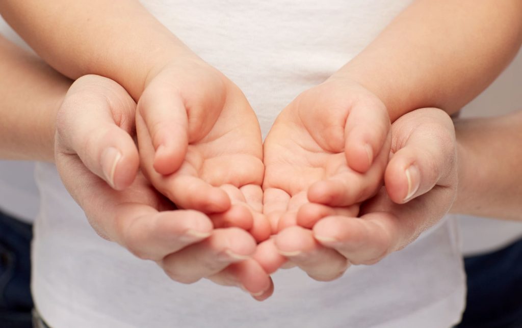 Geschlossene Hände symbolisieren sorgsame Behandlung eingefrorener Eizellen in Griechenland, Ausdruck der Klinikpflege bei IVF.
