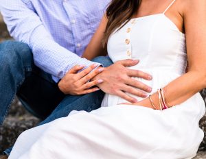 Pregnant woman and partner share a tender moment, hand on belly, celebrating their ivf conception success together.