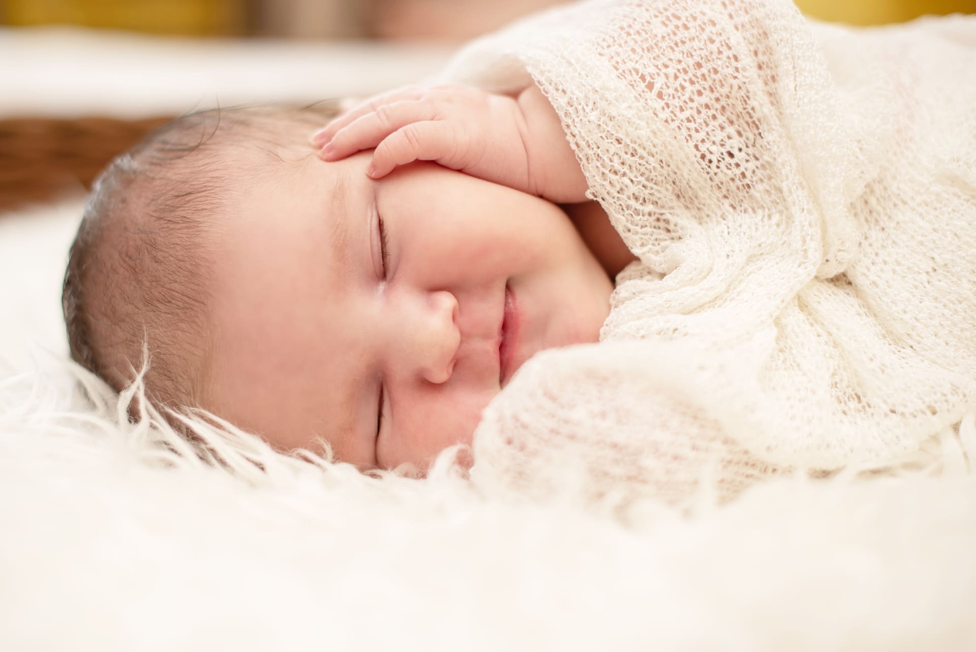 Peaceful newborn baby wrapped in white, symbolizing successful IVF outcome after PCOS treatment.