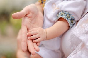 Kleine neugeborene finger umklammern eine erwachsene hand — ein zarter moment nach pgt, der eine gesunde embryonalentwicklung sicherstellte.